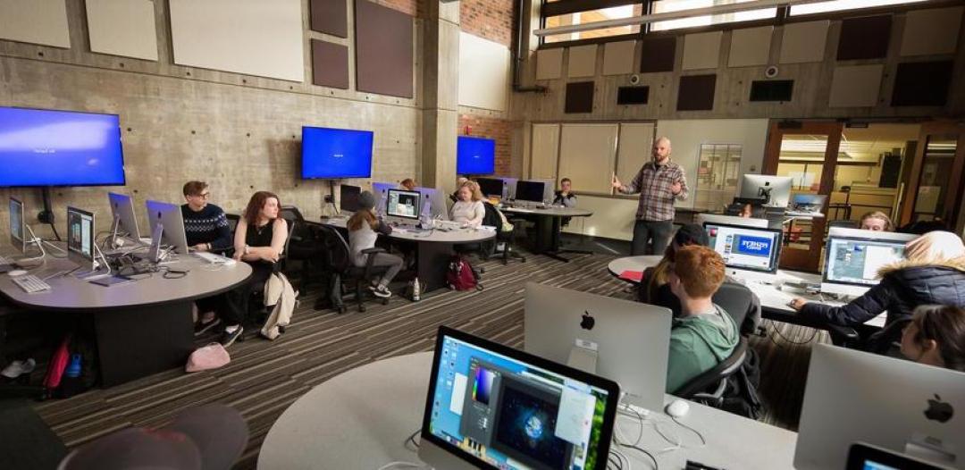 Photo of professor and students in the digital media arts lab